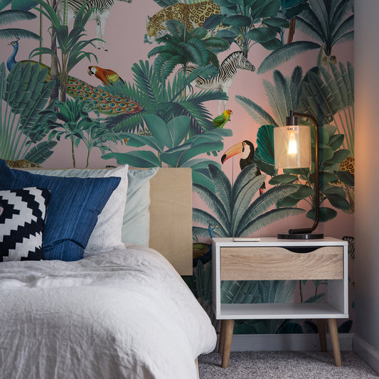 Paradise Garden Pink Wallpaper In Dark Room With White Bed and Bedside Lamp Turned On Lighting Up Part Of The Wall