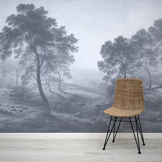 Wicker chair in front of a wall mural depicting a misty landscape with trees and sheep.