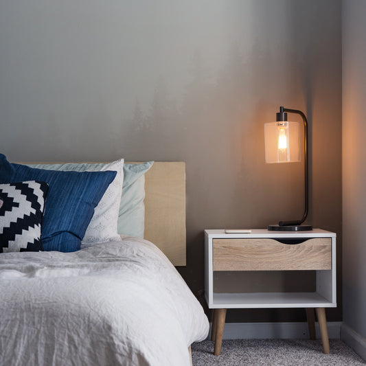 Sepia serenity heights wallpaper in bedroom with close up of bed with white bedding and blue cushions as well as side table next to bed with shining orange sidelamp