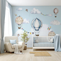 Balloons Wallpaper In Nursery With White Cot And Large Cream Chair With Blue Cushions And Blue Bedding