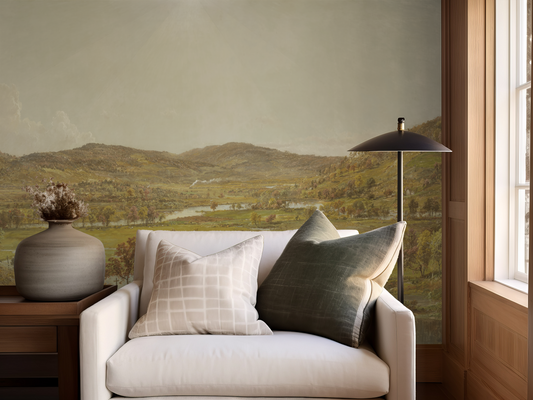 Cozy living room with a white sofa, decorative pillows, and a scenic wall mural.