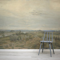 Eowyn Wallpaper with a gray chair in front of a scenic wall mural with a landscape.