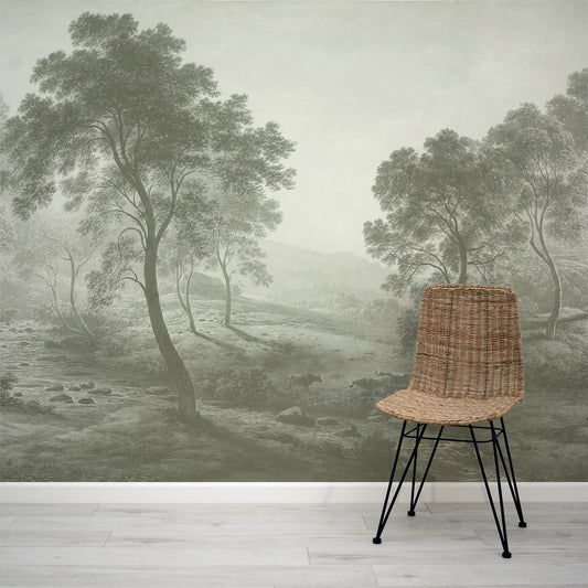 Wicker chair in front of a wall mural depicting a misty green landscape with trees.