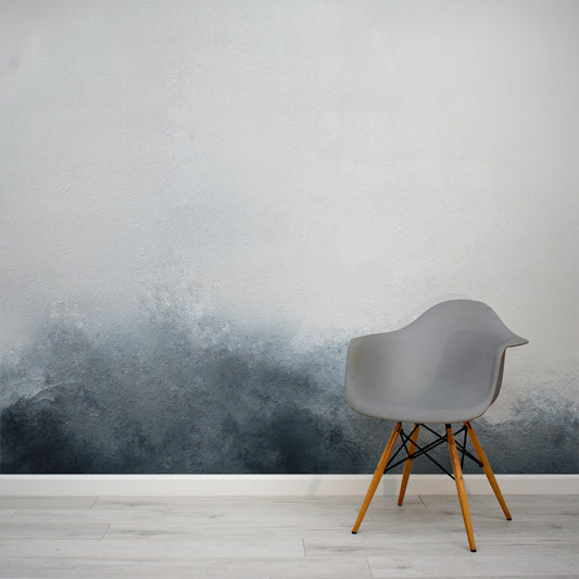 Gray chair with wooden legs against a wall with a gradient design