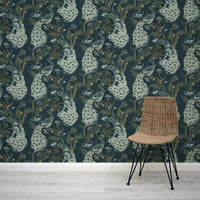 Wicker chair in front of a wall with decorative floral peacock wallpaper