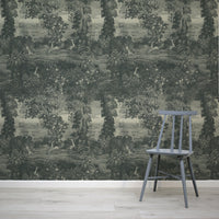 Katharine Indigo Wallpaper Chair in front of a forest-themed wallpaper with birds and foliage.