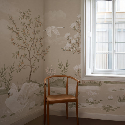 A styled interior corner featuring beige wallpaper with delicate botanical and swan motifs, a wooden chair in the foreground, and a white window on the right.