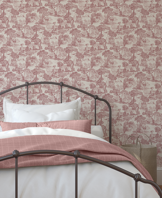 A black iron bed with pink and white covers. Against a pink toile inspired wallpaper 
