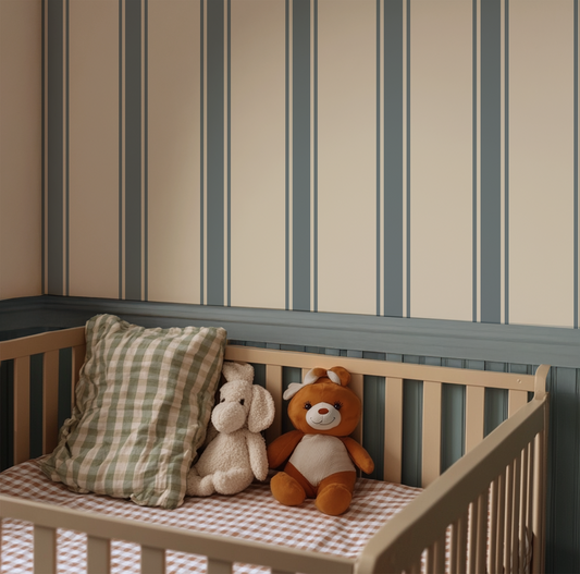 Wooden crib with stuffed animals and a pillow against a striped wall.