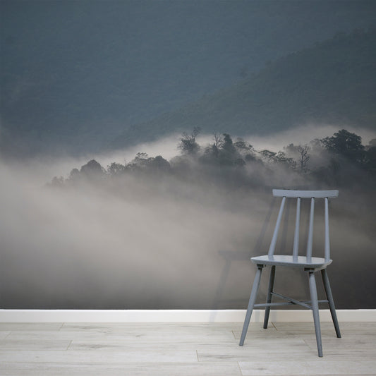 Mystical morning haze wallpaper in living room with grey and bluish chair in front of wallpaper