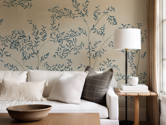 Living room with a white sofa, decorative pillows, and a lamp against a wall with leaf pattern.