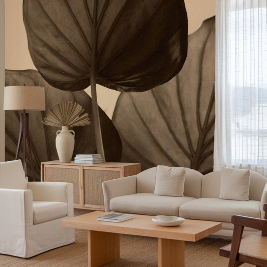 Living room with beige sofa, armchair, and coffee table against a wall with large leaf mural