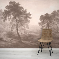 Wicker chair in front of a wall with a forest mural