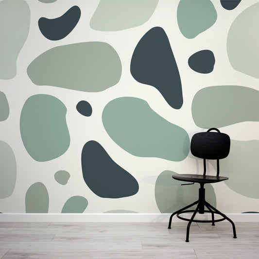 Hamment Neutral Green Abstract Spot Wallpaper Mural with a Minimal Black Desk Chair.